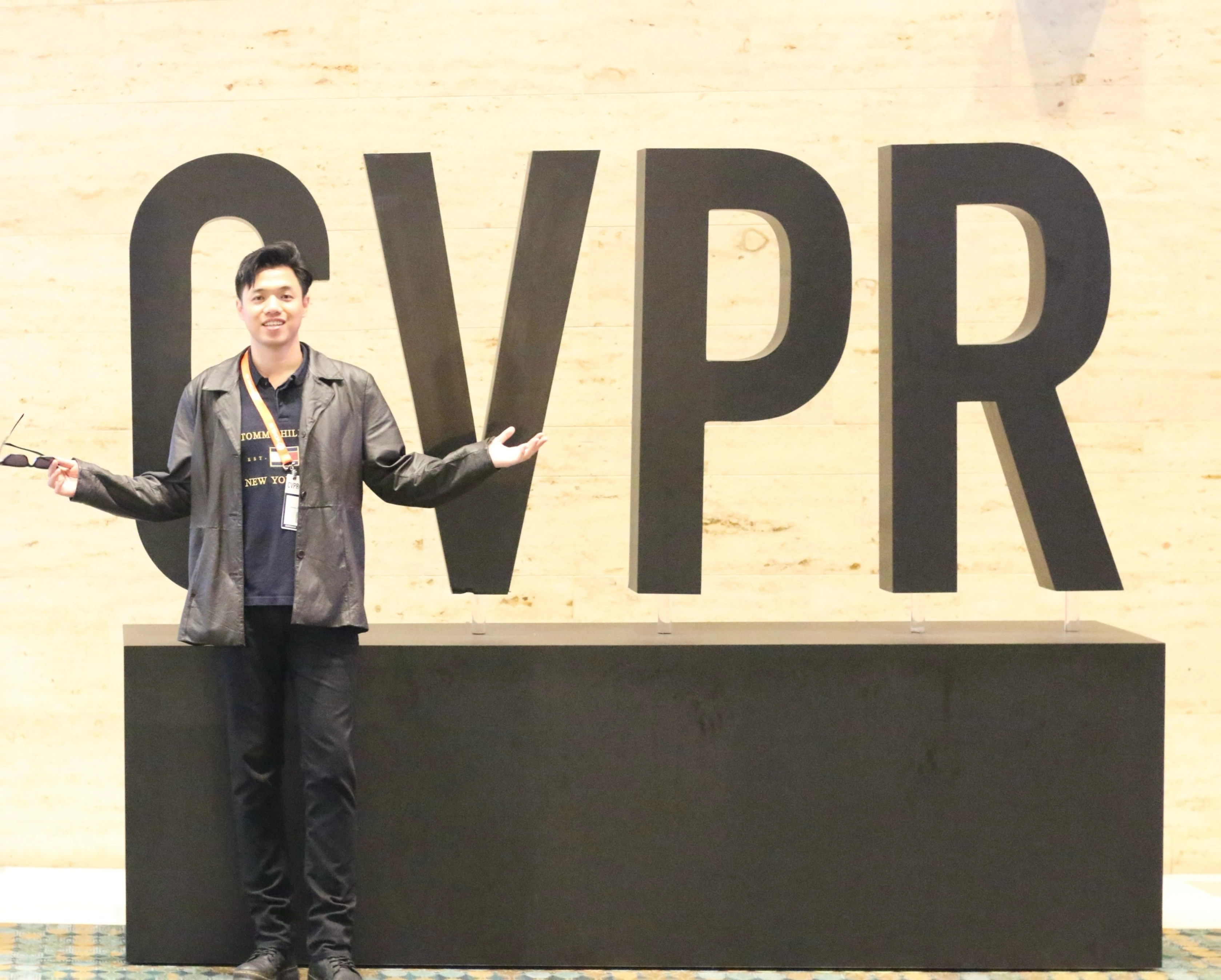 Zilin Huang standing in front of the CVPR sign at CVPR 2025