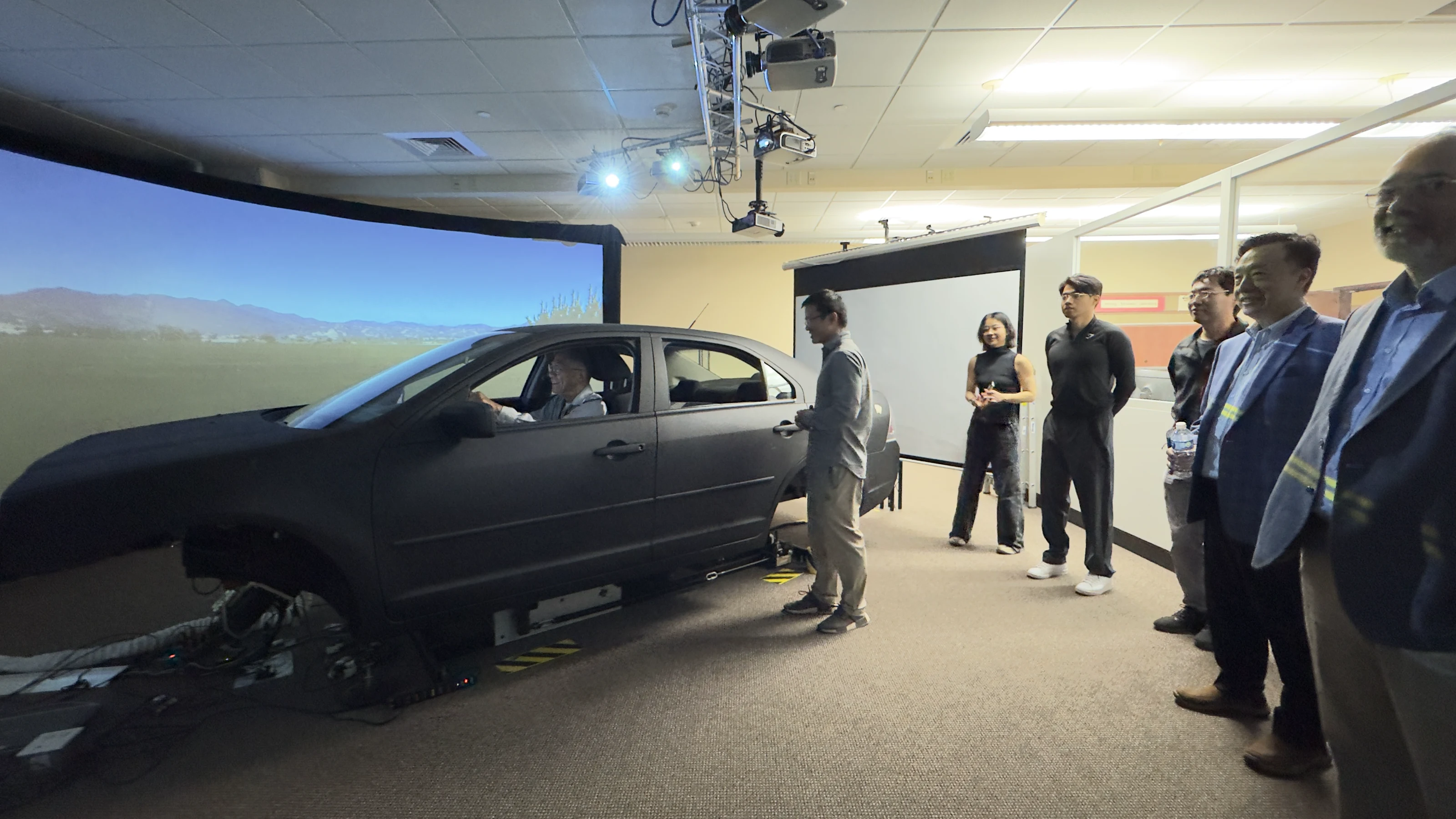 Jong-Shi Pang and visitors viewing the autonomous-driving simulator at UW–Madison