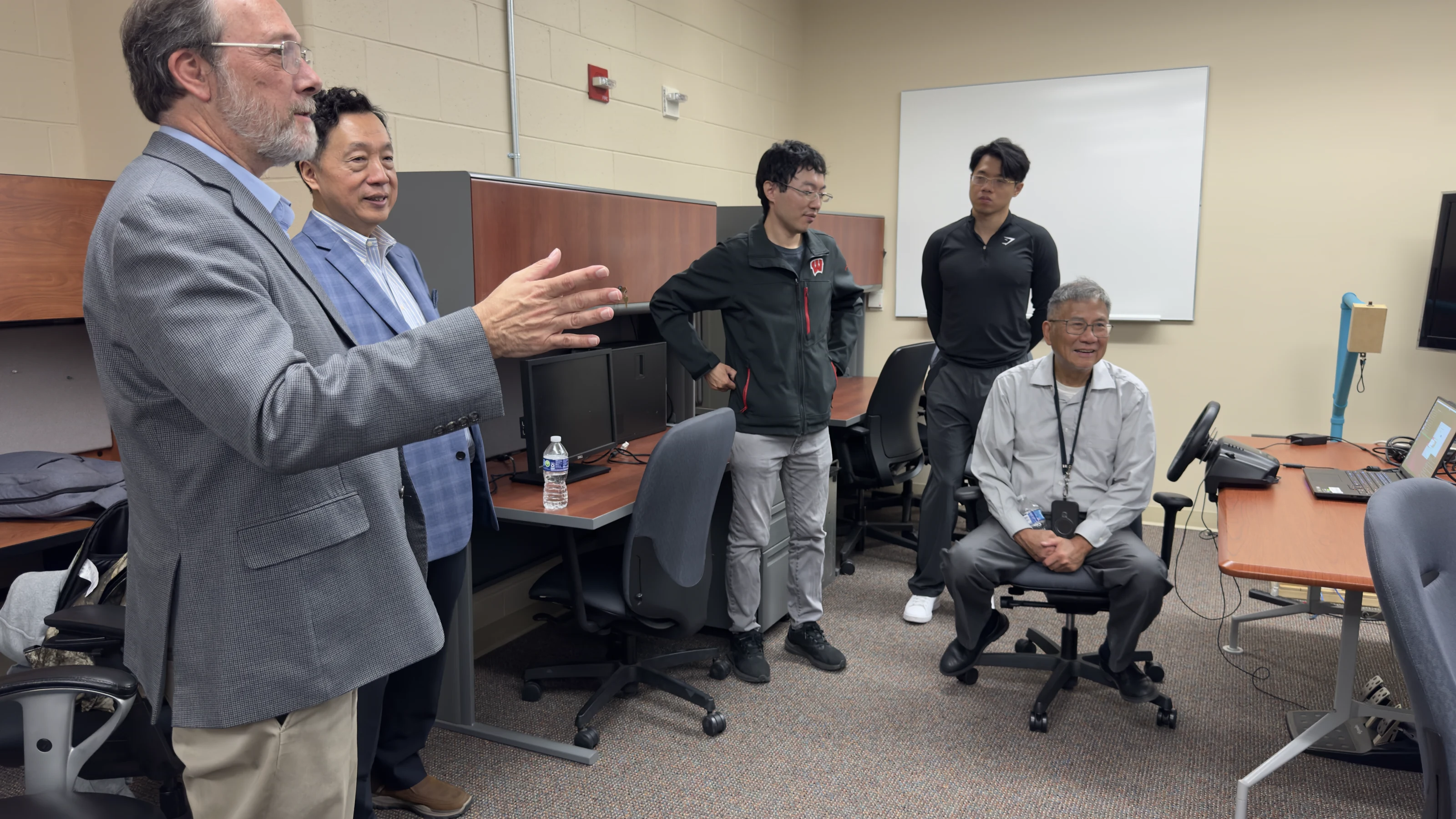 Sky-Lab members discussing the remote-driving system with Jong-Shi Pang and visitors