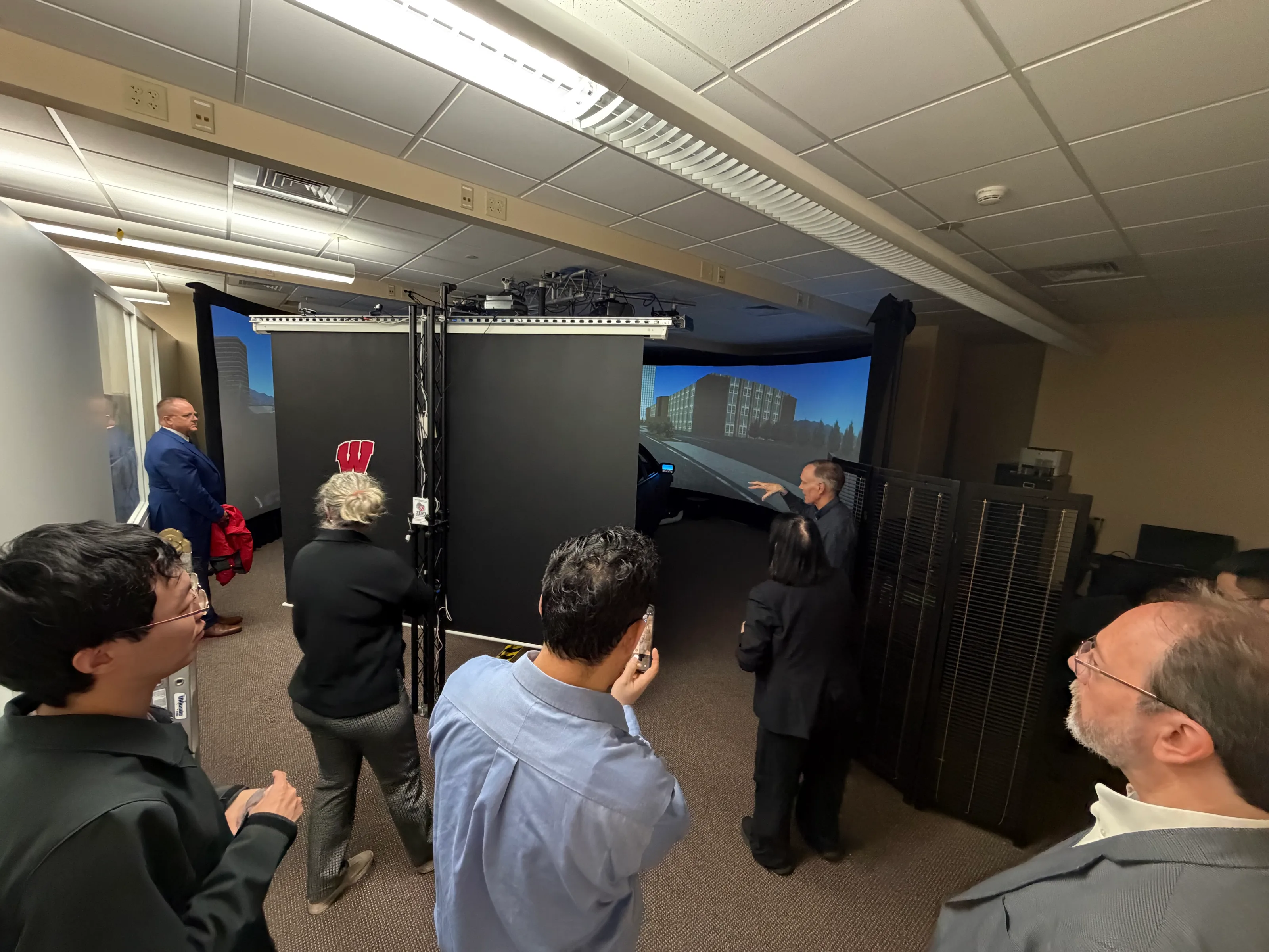 Researchers presenting the remote-driving simulation environment to Eva Lerner-Lam