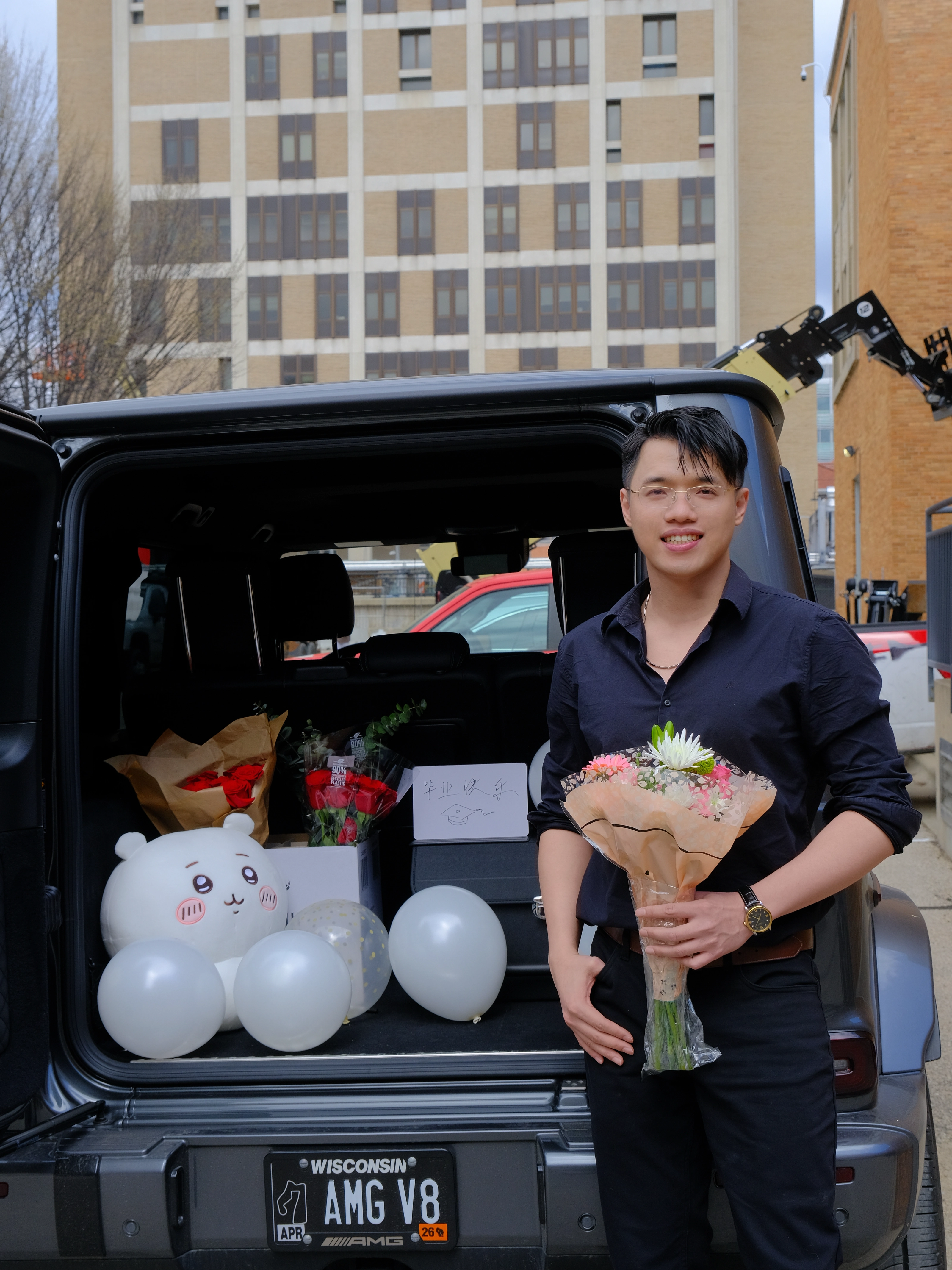 Zilin Huang holding flowers after successfully defending his Ph.D. dissertation