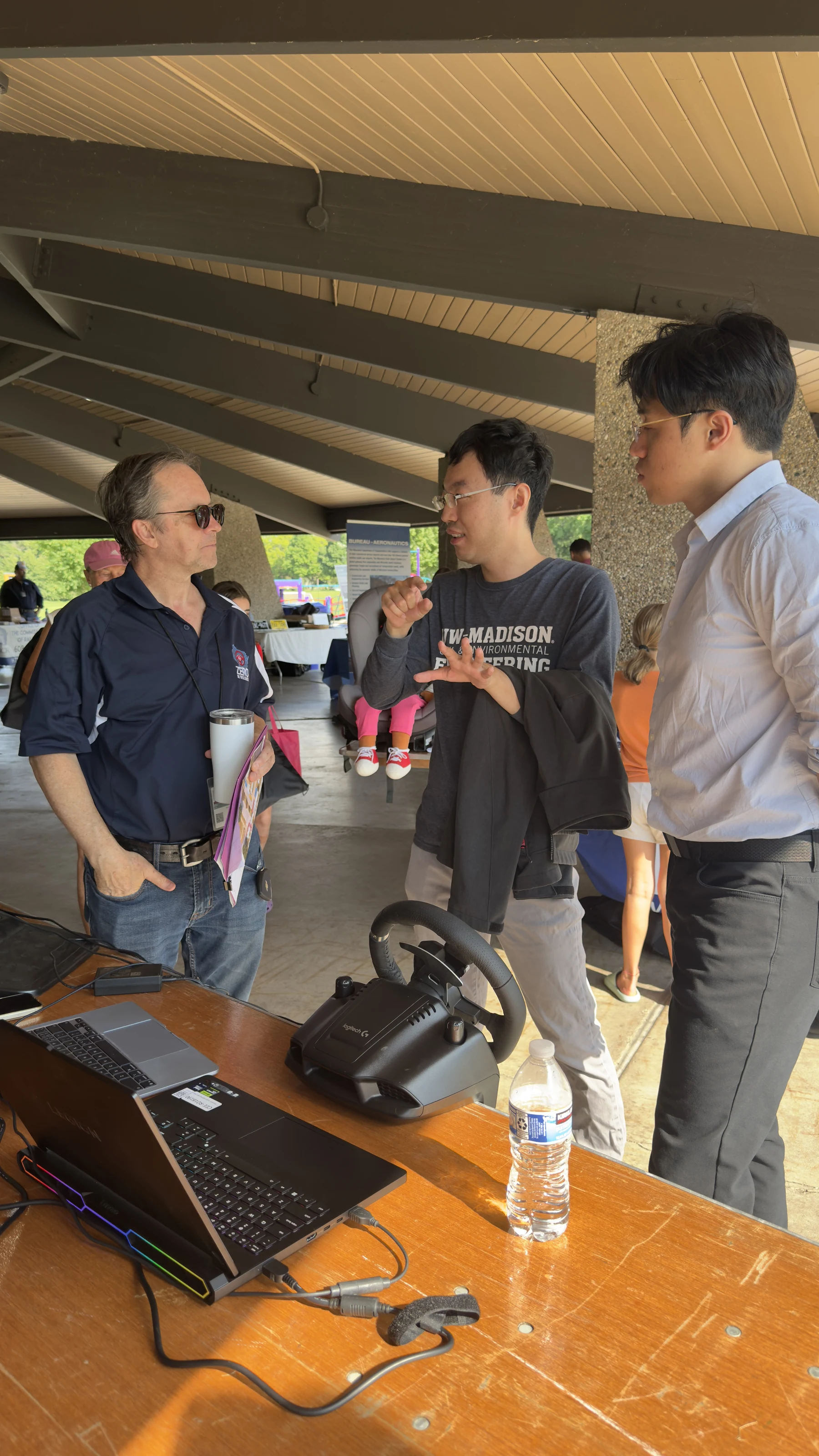 Researchers discussing remote-driving technology with a community visitor